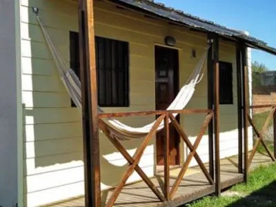 Frente de la Cabaña 1 con galería de madera y hamaca paraguaya