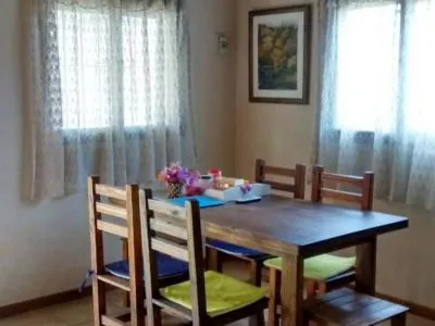 Comedor con mesa de madera y cortinas de encaje