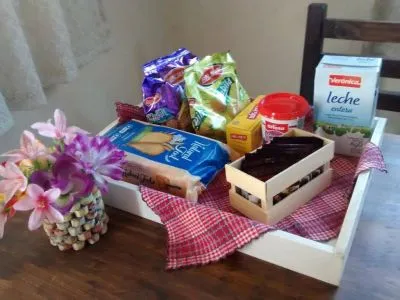 Desayuno servido sobre la mesa con flores y mantel a cuadros
